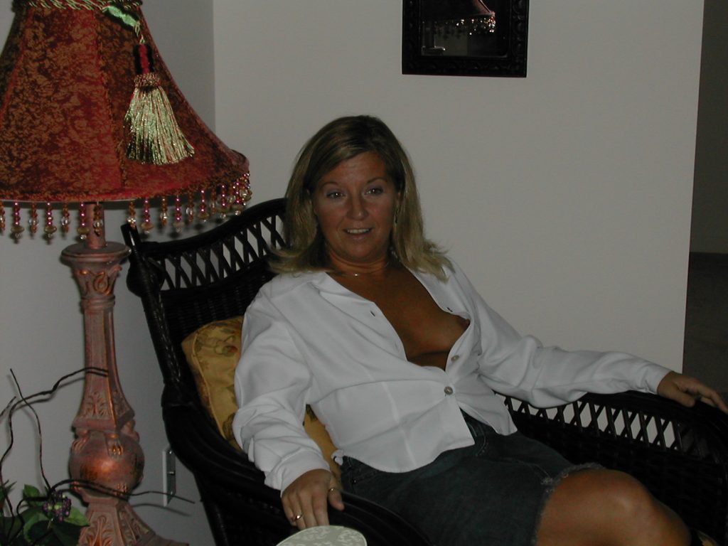 Sexy Blonde MILF Wife Revealing Her Nipple While Sitting In Chair Wearing Unbuttoned White Shirt.